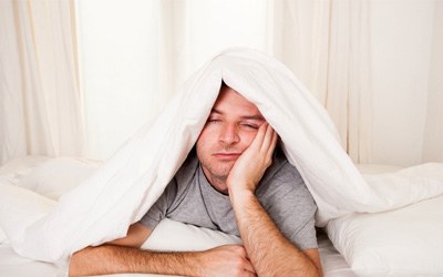 Man with sleep apnea in Wayland, MA lying awake in bed