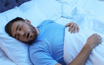 Man with sleep apnea in Wayland, MA snoring in bed