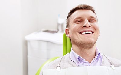 Man sitting in dental chair and smiling