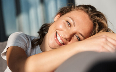 woman with bright smile sitting on a couch