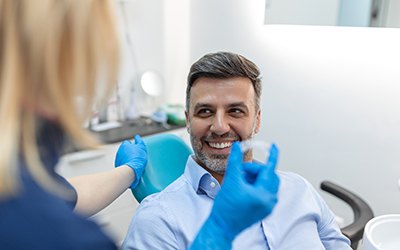 Female dentist showing male patient an Invisalign aligner