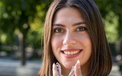 Woman putting in aligner for Invisalign in Wayland, MA 