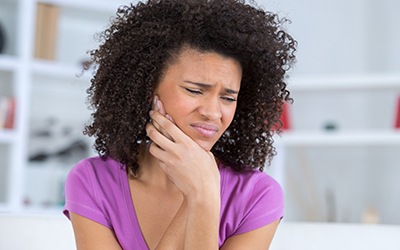 Woman in purple shirt with jaw pain